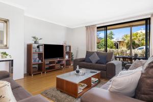 a living room with a couch and a tv at Baudins of Busselton Bed and Breakfast - Adults only in Busselton