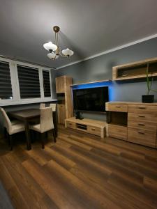 salon ze stołem i dużym telewizorem w obiekcie Luxury Aparments Klimatyzacja z Prywatnym Parkingiem w Radomiu