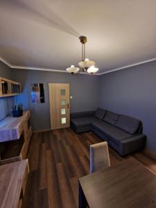 a living room with a couch and a table at Luxury Aparments Klimatyzacja z Prywatnym Parkingiem in Radom