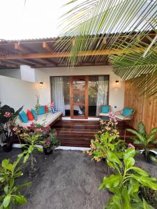 ein Haus mit einer Terrasse mit Stühlen und Pflanzen in der Unterkunft Seaside Dhigurah in Dhigurah