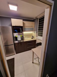 kuchnia z brązowymi szafkami, stołem i krzesłem w obiekcie Luxury Aparments Klimatyzacja z Prywatnym Parkingiem w Radomiu