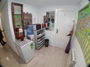 a small room with a refrigerator and a mirror at Pensión La Estación in Logroño