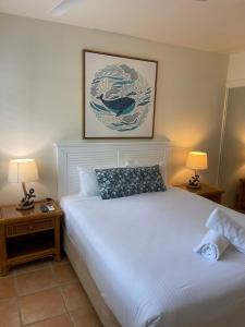 a bedroom with a white bed with two night stands at The Cove Yamba in Yamba
