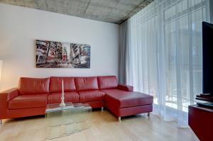 sala de estar con sofá rojo y ventana en Les Immeubles Charlevoix - Le 760204 en Quebec