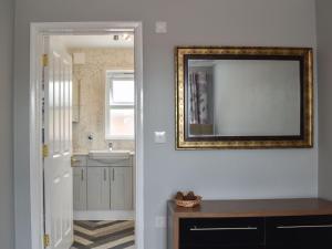 a bathroom with a mirror and a sink at The Fairway in Westgate-on-Sea