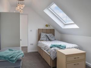 a bedroom with a bed and a skylight at The Fairway in Westgate-on-Sea