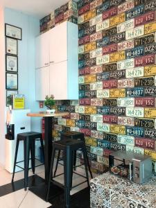 a kitchen with two stools in front of a wall covered in graffiti at Best View Hotel Puchong in Puchong