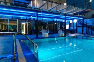 a swimming pool at night with blue lights at Blue Sky Residence Airport in Ban Bang Phli Yai
