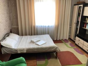 ein Schlafzimmer mit einem Bett mit zwei Büchern darauf in der Unterkunft Homestay JAISEL in Bischkek