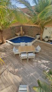 a patio with a pool and a table and chairs at ريفان لبيوت الضيافة خاصة in Yanbu