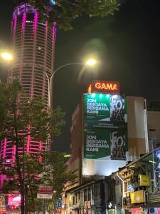 une ville la nuit avec un bâtiment avec des panneaux de néons dans l'établissement G99 Hotel, à George Town