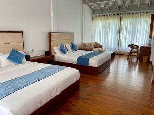 pokój hotelowy z 2 łóżkami i kanapą w obiekcie Atteriya HILLTOP w mieście Matara