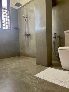 uma casa de banho com um chuveiro e um WC. em Atteriya HILLTOP em Matara