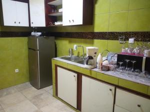eine Küche mit einer Spüle und einem Kühlschrank in der Unterkunft Arbre de Paix 40/1.1 in Douala