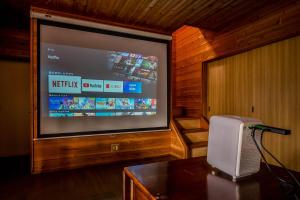 a large screen television in a living room with a speaker at Stella Rental Villa Engawa House in Fujikawaguchiko