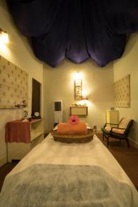 a bedroom with a bed with a red stuffed animal on it at Red Earth Kabini in Begūr