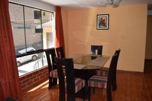a dining room with a table and chairs and a window at Departamento excelente ubicación in Cusco