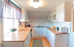 KlintehamnにあるNice Home In Klintehamn With 2 Bedrooms And Wifiのキッチン(白いキャビネット、電子レンジ付)