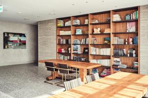 a dining room with a table and a book shelf at La Casa hotel Gwangmyeong in Gwangmyeong