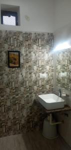 baño con lavabo y pared de azulejos en Jawai Leopard Villa, en Bijāpur