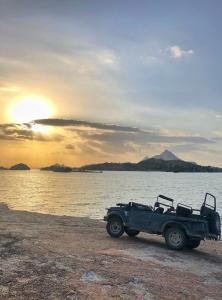 a jeep parked on the beach with the sunset at Jawai Leopard Villa in Bijāpur