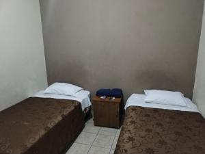 two beds sitting next to each other in a room at Hotel España in Guatemala