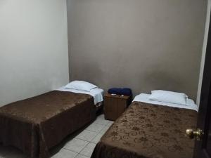 a room with two beds and a door with a door at Hotel España in Guatemala