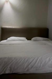a bed with white sheets and pillows on it at G99 Hotel in George Town
