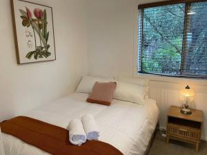 um pequeno quarto com uma cama com toalhas em Games Room & Ocean View em Kiama