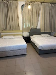 two beds sitting in a room with curtains at G99 Hotel in George Town