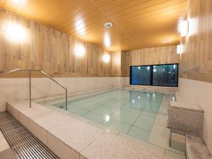 a large swimming pool in a room with a tv at La'gent Hotel Kyoto Nijo in Kyoto