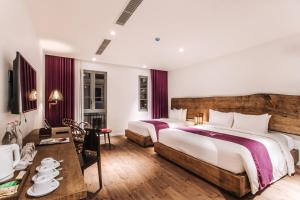 a hotel room with two beds and a table at JM Boutique Hotel in Phú Quốc