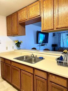 a kitchen with a sink and wooden cabinets at Kona Joe Coffee Farm in Kealakekua