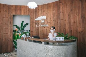 a woman sitting at a desk with a laptop at JM Boutique Hotel in Phú Quốc
