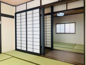 an empty room with a room with sliding glass doors at 東京民泊 貸し切り一軒家 モダン和風 畳 青砥 上野 プライベート空間 最大8名 in Tokyo