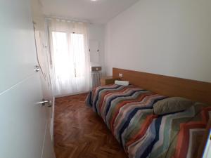 - une chambre avec un lit doté d'une couette à rayures et d'une fenêtre dans l'établissement Apartamento Turístico Miguel - Logroño, à Logroño