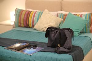 een bed met een handtas en een boek en een boek bij Sea & Sun Guest House in Sant'Agnello