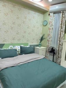 ダバオシティにあるQuirino Hub Charming hotel 1 BRの青いベッドと窓のある寝室