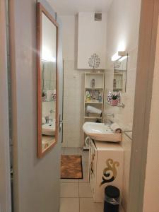 uma casa de banho com um lavatório e um espelho em Le Ty Rose em Dinan