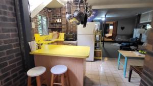 a kitchen with a yellow counter and stools at Nature's Melody Share Home in Brisbane