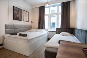 a bedroom with two beds and a table and a window at Dream Apartments - Gdańska 72 in Łódź