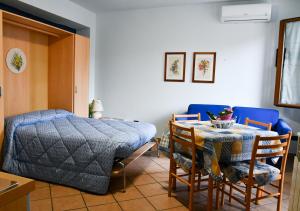 a bedroom with a bed and a table and chairs at Gli Angeli Agriturismo in Cisano sul Neva