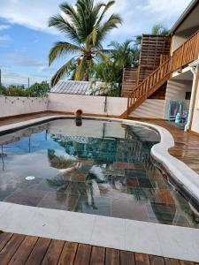 una piscina con terraza y una palmera en Ti Piment, en La Possession