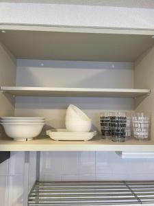 a shelf with bowls and plates on it at 500mfrom Sta first internet cozy in Shin-kotoni