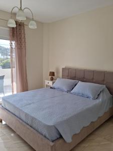 a bedroom with a large bed with blue pillows at Ma Maison Bleue in Kremasti