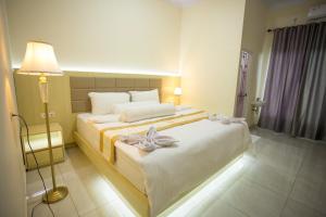 een slaapkamer met een groot wit bed en een lamp bij HAYANA HOTEL in Taruna