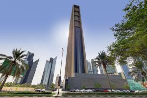 uma torre alta com palmeiras em frente a uma cidade em Primestay - Index Tower, DIFC no Dubai