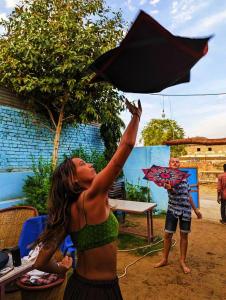 Eine Frau im Bikini, die einen schwarzen Regenschirm hält. in der Unterkunft Veera's Hostel in Pushkar