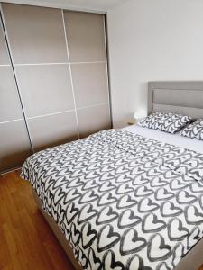 - une chambre avec un lit et une couette noire et blanche dans l'établissement Apartman Malmar One, à Zagreb