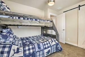 a bedroom with a bunk bed with a blue and white quilt at Gypsum Home with Patio Between Glenwood and Vail in Eagle
